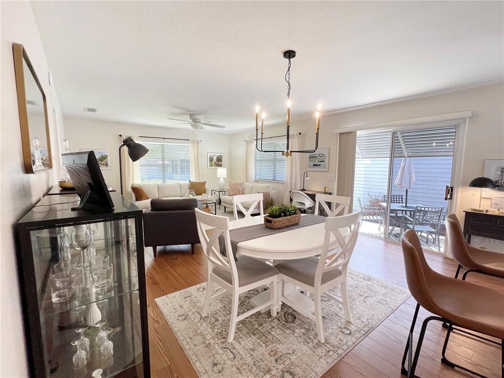 A dining area with a white table and chairs sits adjacent to a living room — 2146 ESTEVEZ DRIVE, THE VILLAGES, FL