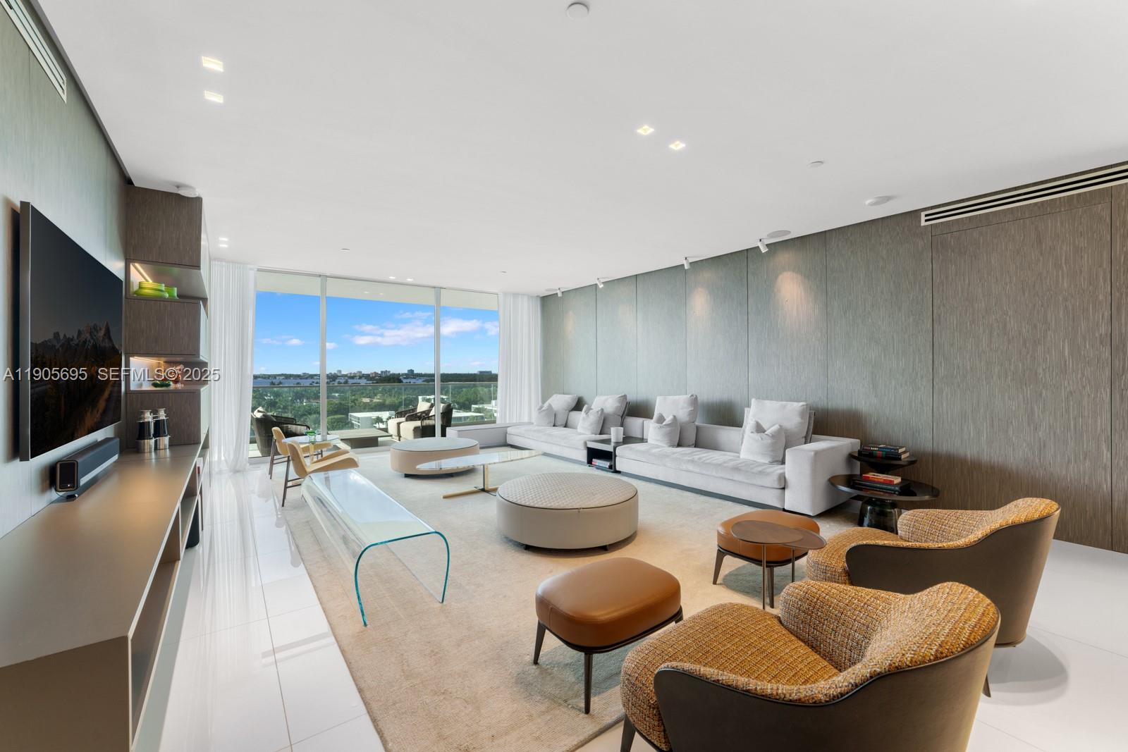 A modern living room features a large sectional sofa, glass coffee table, and floor-to-ceiling windows — 10201 Collins Ave # 807, Bal Harbour FL 33154, BAL HARBOUR, FL