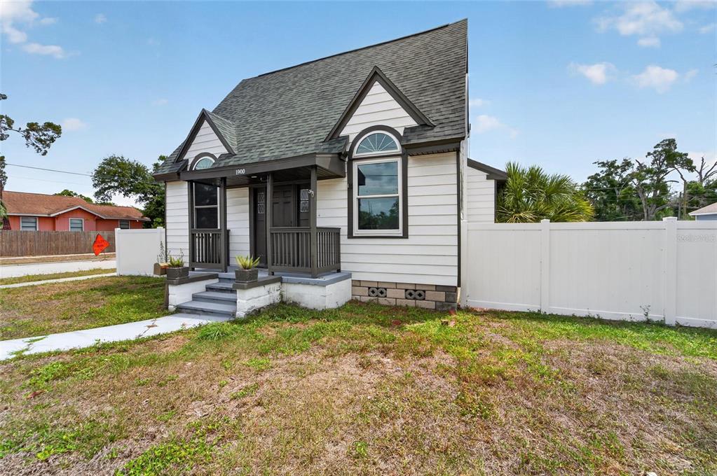 A white house with a dark shingled roof, a front porch, and a white fence — 1900 16TH STREET S, ST PETERSBURG, FL