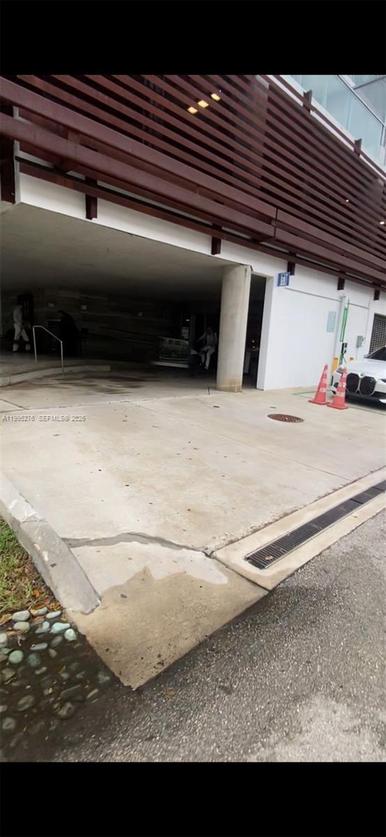 This exterior view shows a concrete driveway leading to a covered building entrance — 1215 W Ave Parking, Miami Beach FL 33139, MIAMI BEACH, FL