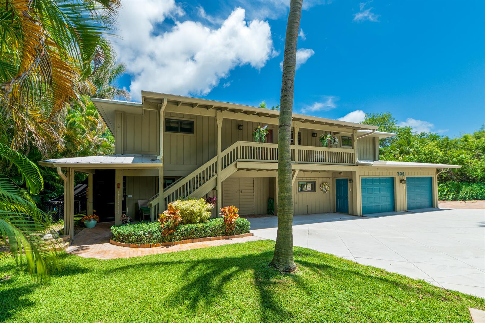 A two-story house with a wooden exterior, a staircase, and a concrete driveway — 304 SW Indian Groves Drive, Stuart FL 34994, STUART, FL