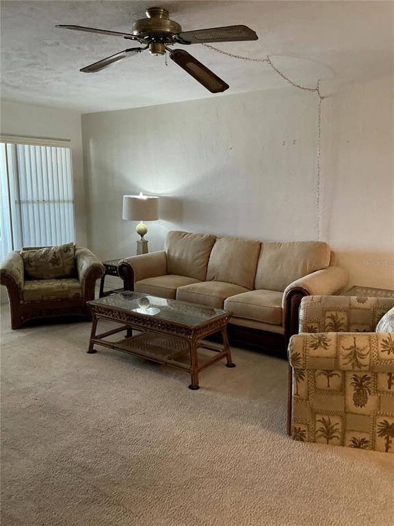 A living room features a beige sofa, two patterned armchairs, and a ceiling fan — 4300 58TH STREET N UNIT 1913, KENNETH CITY, FL