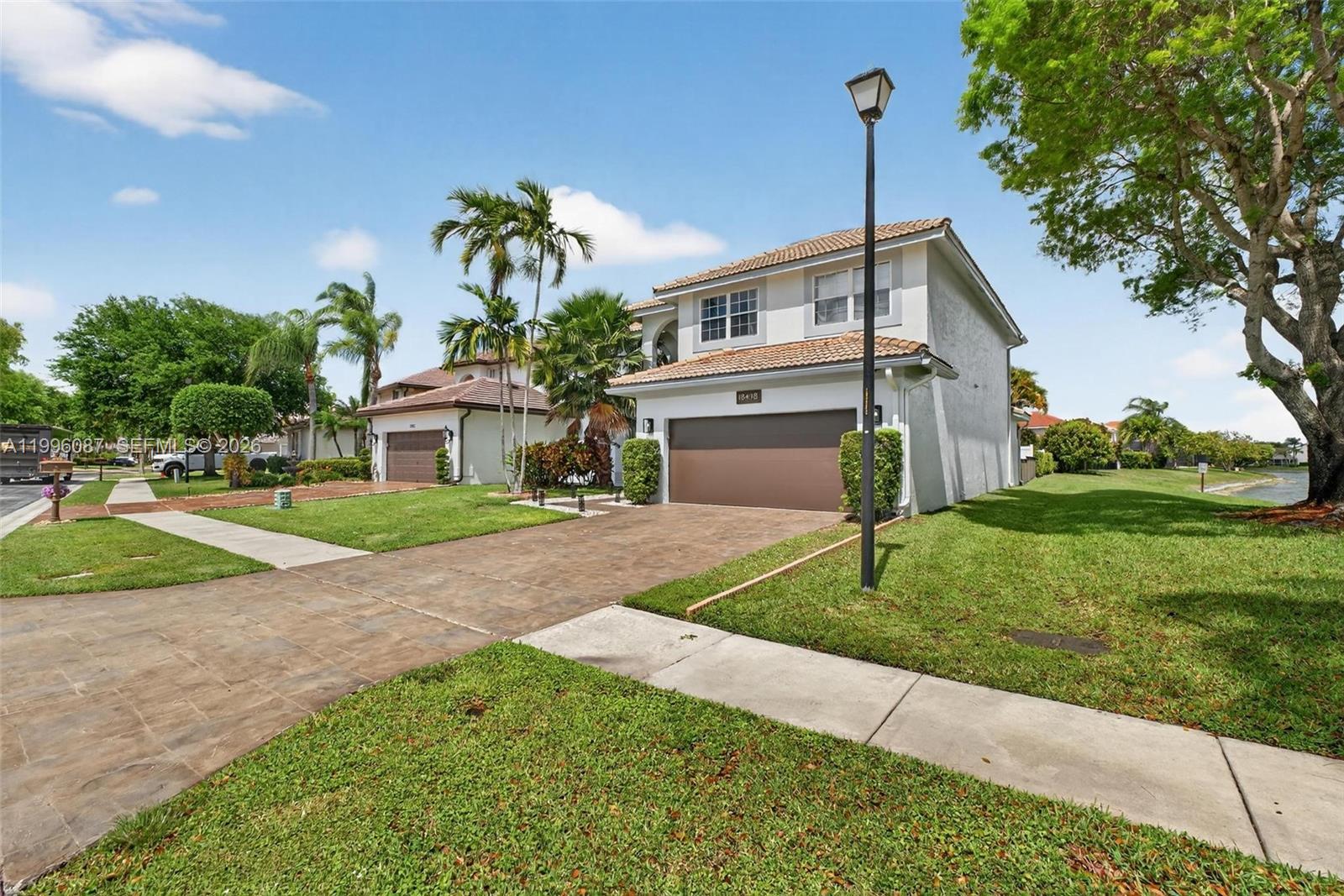 A two-story suburban house with a brown garage door and a paved driveway — 18498 E Covington Trce, Boca Raton FL 33498, BOCA RATON, FL