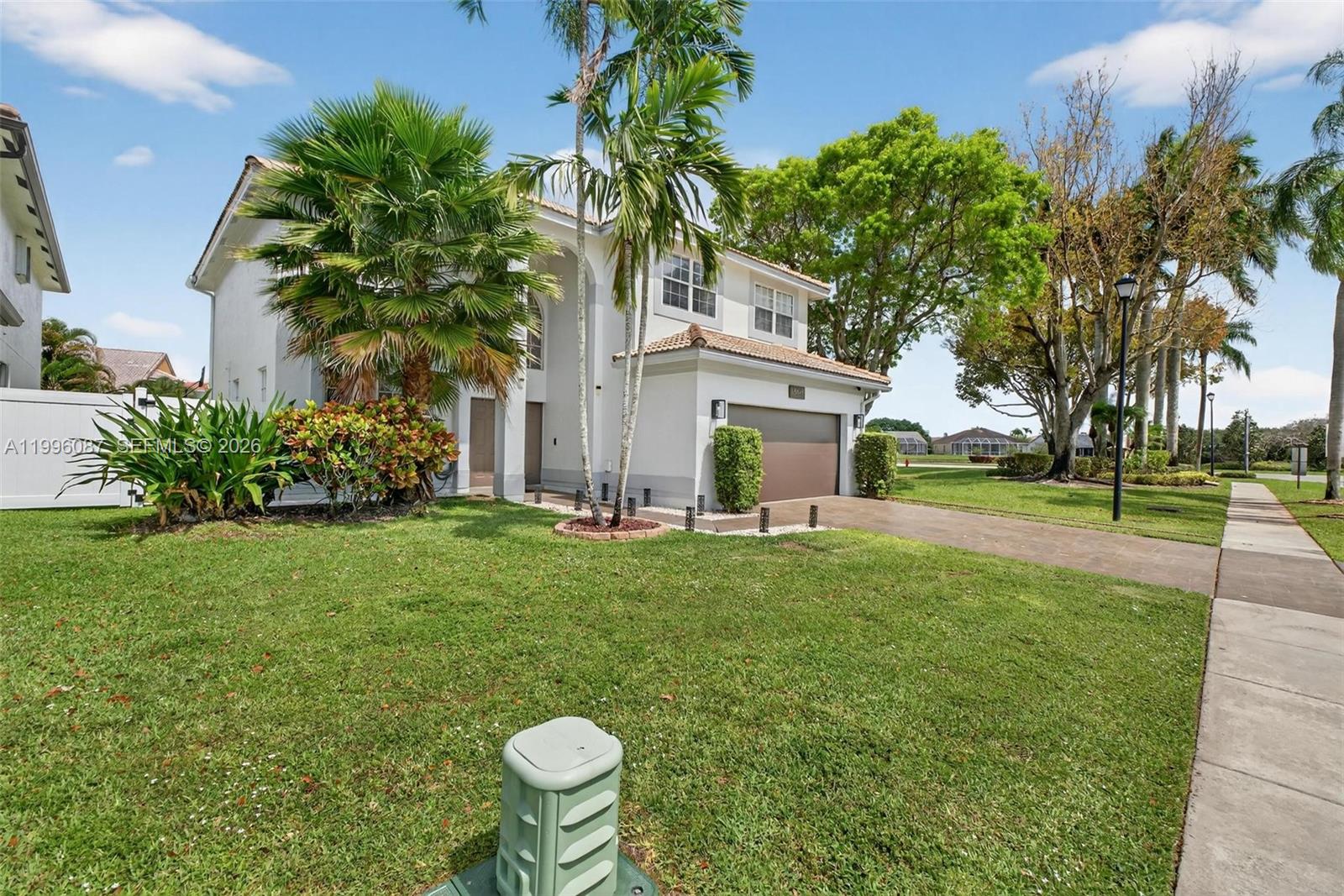 A two-story house with a white exterior, a brown garage door, and palm trees — 18498 E Covington Trce, Boca Raton FL 33498, BOCA RATON, FL