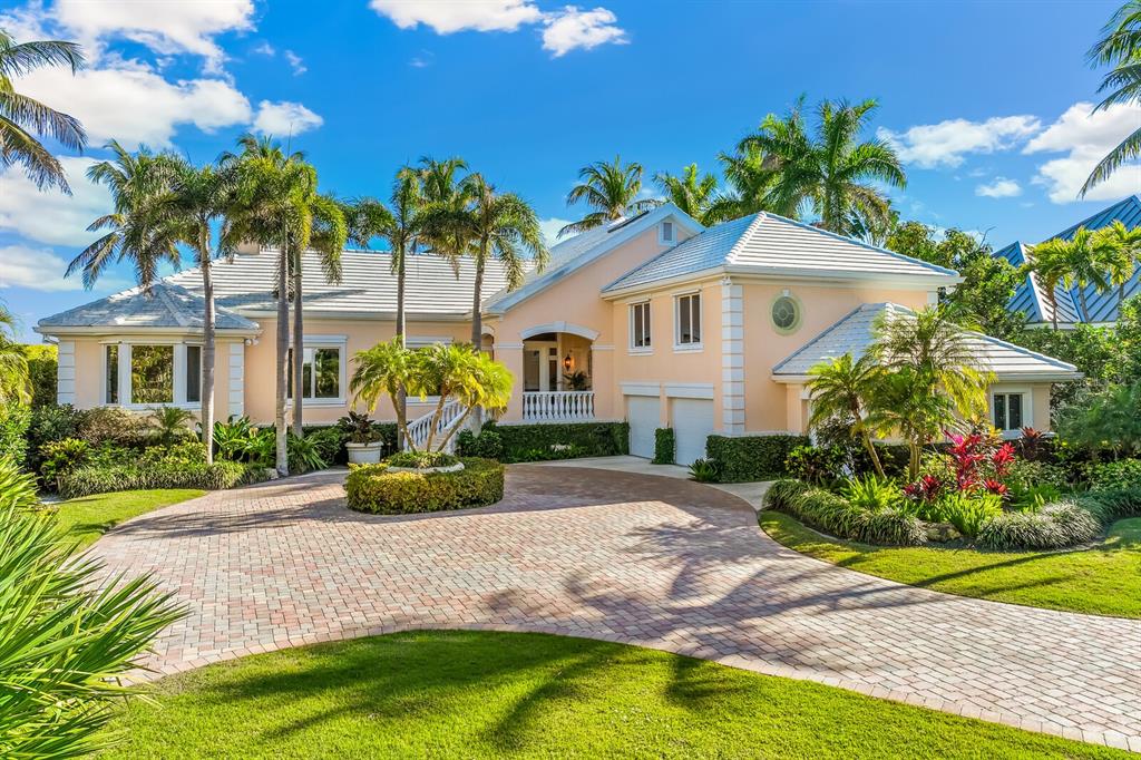 A peach-colored house with a tiled roof and a circular brick driveway surrounded by palms — 1640 JEAN LAFITTE DRIVE, BOCA GRANDE, FL