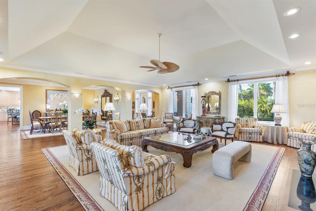 A spacious living room features a vaulted ceiling, wood floors, and patterned upholstered furniture — 1640 JEAN LAFITTE DRIVE, BOCA GRANDE, FL