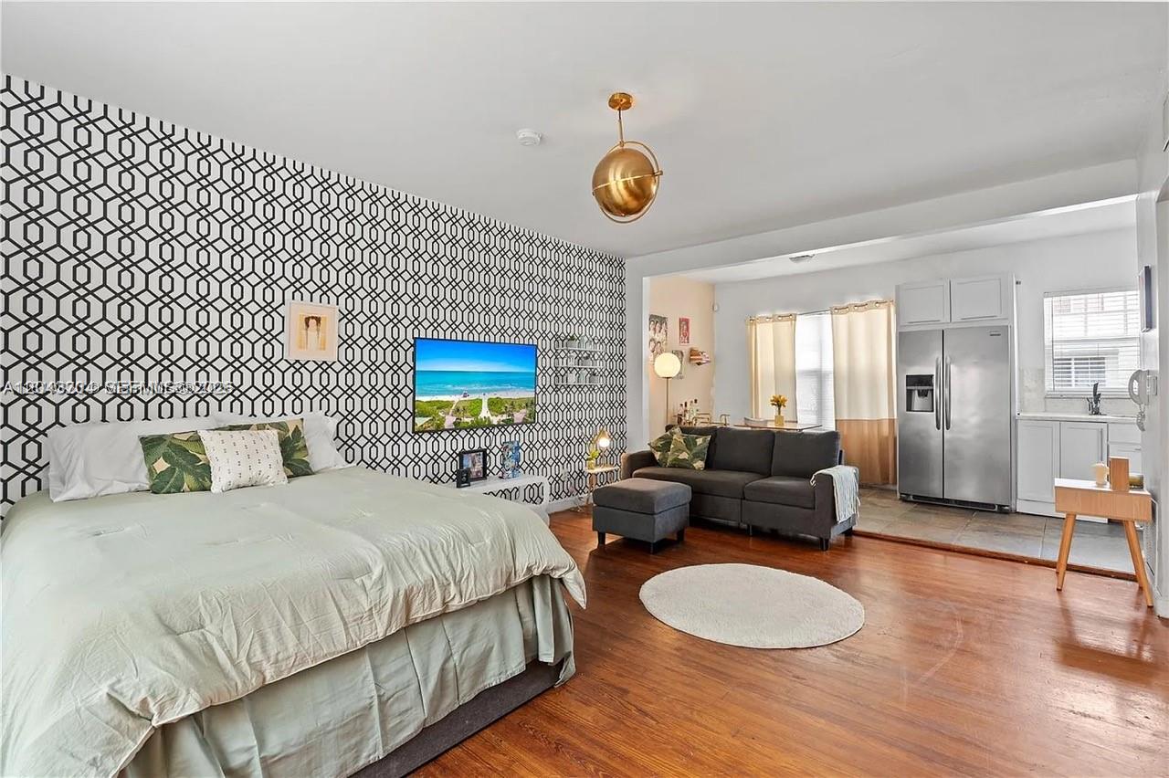A studio apartment features a bed, a gray sofa, and a kitchen with stainless appliances — 760 Meridian Ave # 3, Miami Beach FL 33139, MIAMI BEACH, FL