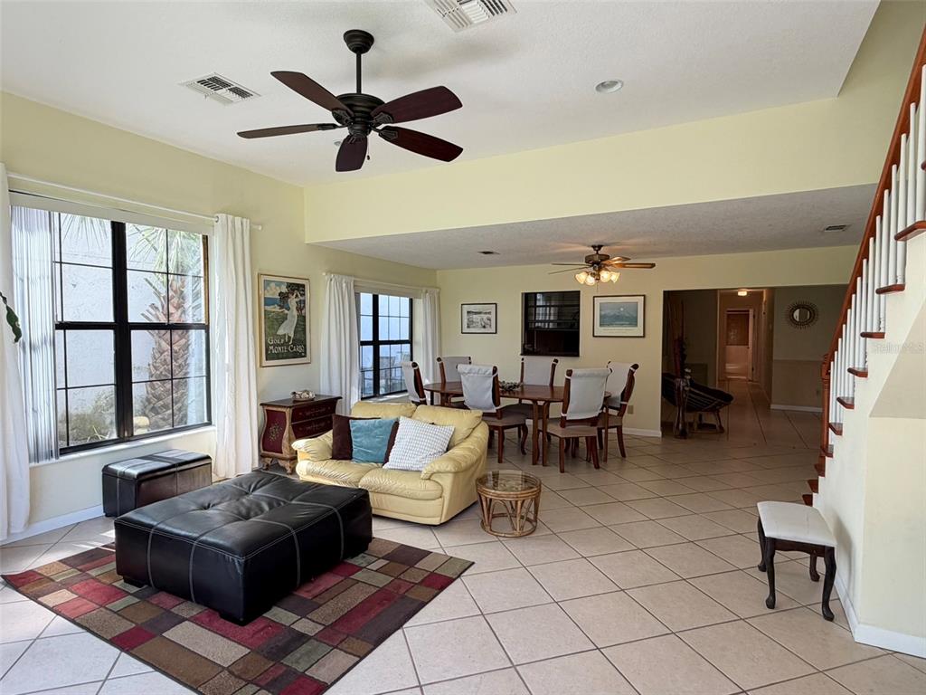 A living and dining area with tile floors, a ceiling fan, and a staircase — 2570 SHADYBRANCH DRIVE, ORLANDO, FL