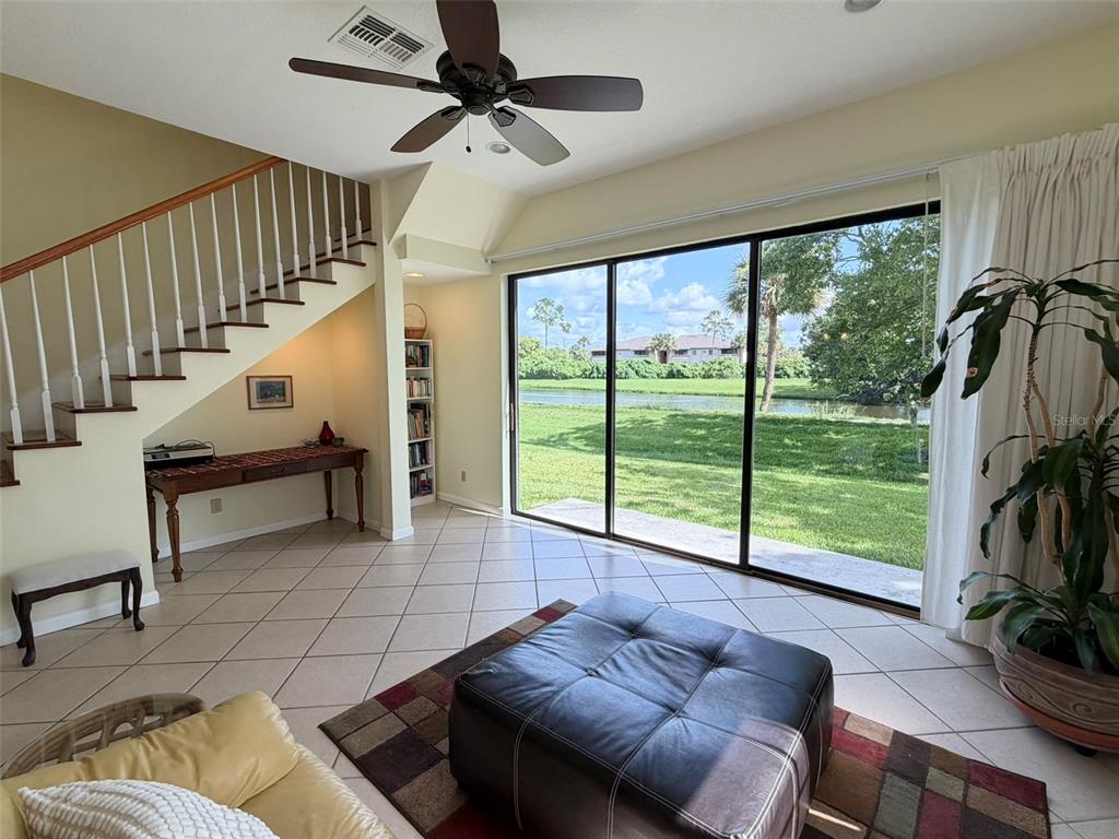 A living room features tile floors, a staircase, a ceiling fan, and large sliding glass doors — 2570 SHADYBRANCH DRIVE, ORLANDO, FL