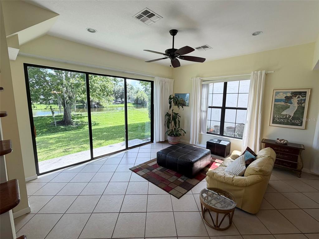A living room features tile flooring, a ceiling fan, sliding glass doors, and a view — 2570 SHADYBRANCH DRIVE, ORLANDO, FL