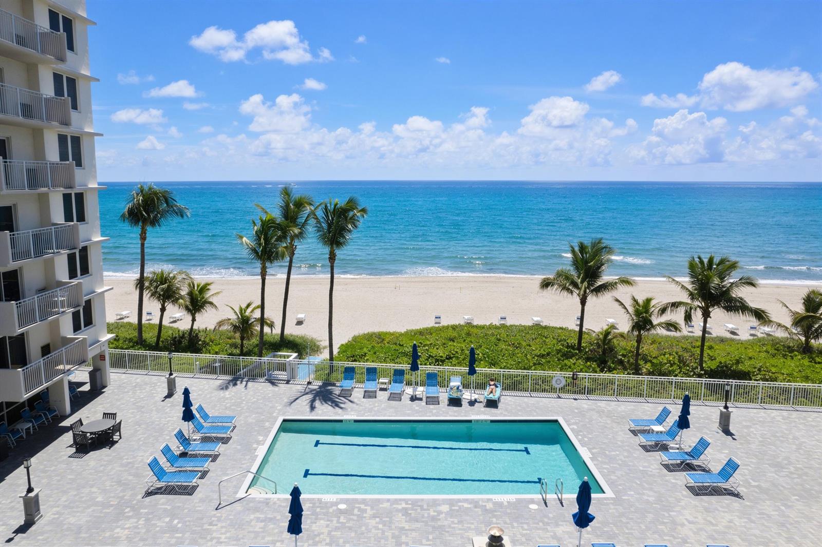 An elevated view of a swimming pool on a patio overlooking a beach and ocean — 3301 S Ocean Boulevard # 109, Highland Beach FL 33487, HIGHLAND BEACH, FL