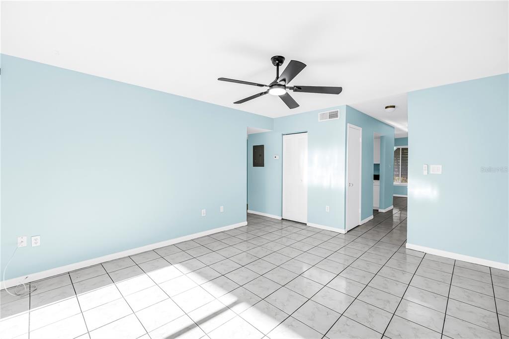 A room with light blue walls, white tile floors, and a black ceiling fan — 3795 41ST LANE S UNIT H, ST PETERSBURG, FL