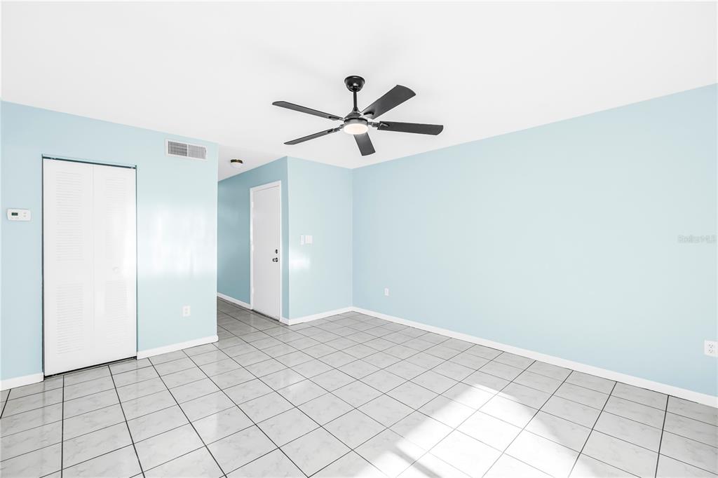 An empty room with light blue walls, white trim, and white tiled flooring — 3795 41ST LANE S UNIT H, ST PETERSBURG, FL