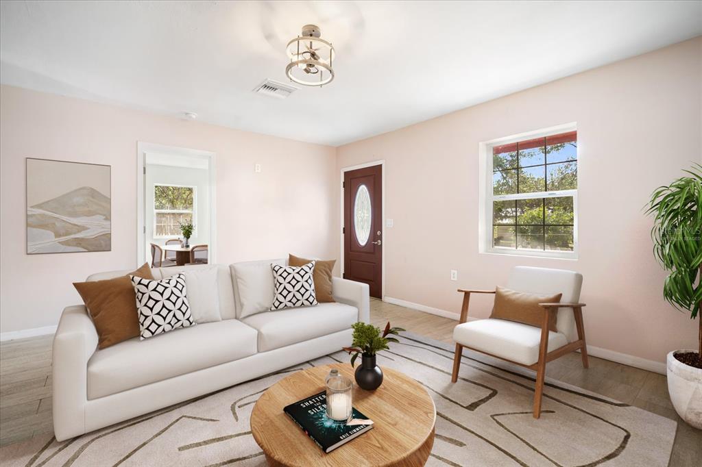 A living room features a white sofa, an armchair, a round coffee table, and light walls — 15229 MYRTLE STREET, DADE CITY, FL