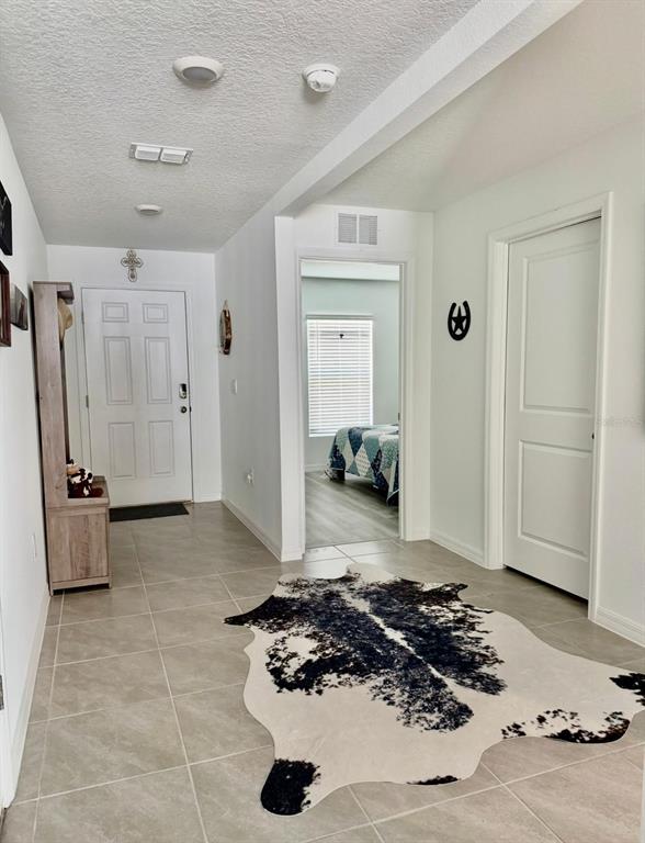 An entryway features tile flooring, a cowhide rug, a wooden hall tree, and white doors — 3561 SW 150TH LOOP, OCALA, FL