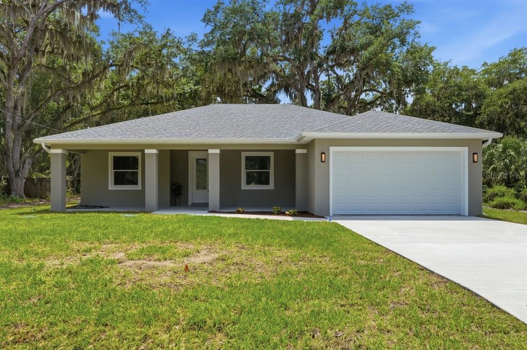 A single-story house with a gray exterior, a two-car garage, and a covered front porch — 2030 HONTOON ROAD, DELAND, FL
