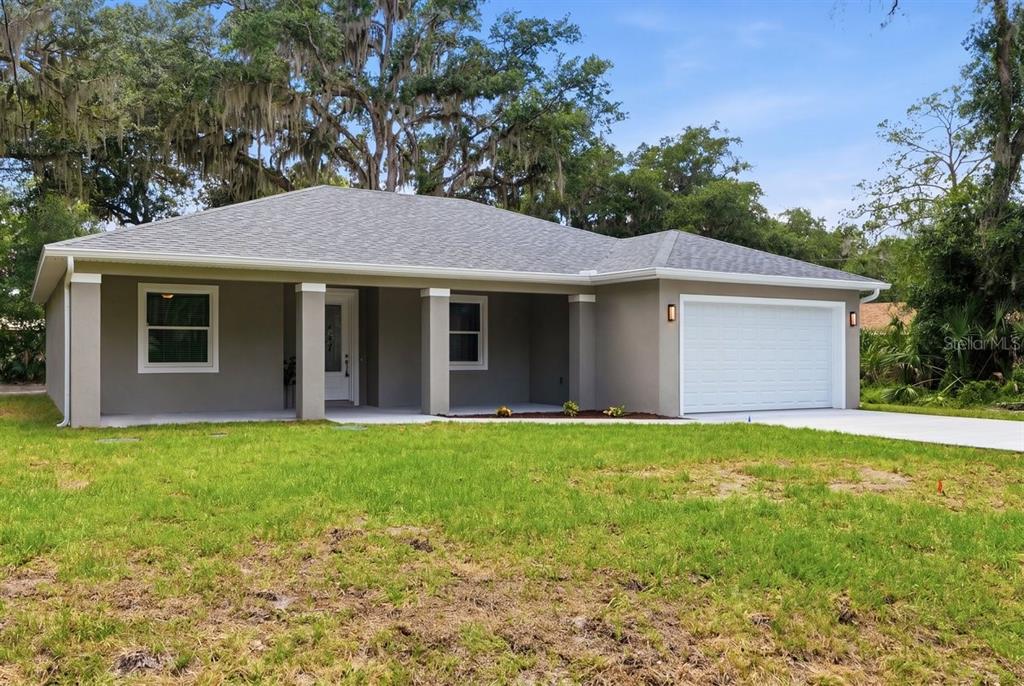 A single-story house with a gray exterior, a covered front porch, and an attached garage — 2030 HONTOON ROAD, DELAND, FL