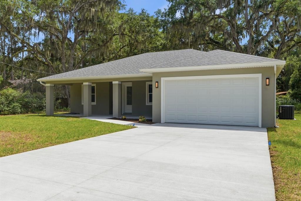 A single-story house with a gray exterior, a two-car garage, and a covered front porch — 2030 HONTOON ROAD, DELAND, FL