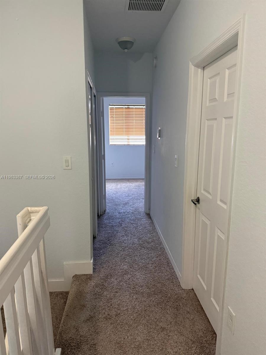 A carpeted hallway leads to a bedroom with a window and blinds — 10776 NW 83rd Ter # 19, Doral FL 33178, DORAL, FL