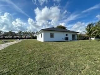 A white, single-story house with a dark roof sits on a large, grassy lot — 1468 NW 100th St, Miami FL 33147, MIAMI, FL