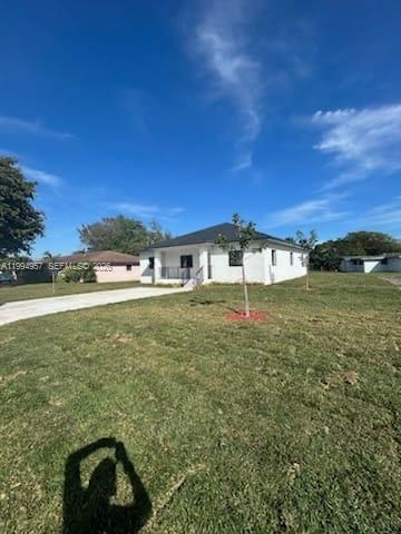 A white, single-story house with a dark roof stands on a large, grassy lot — 1468 NW 100th St, Miami FL 33147, MIAMI, FL