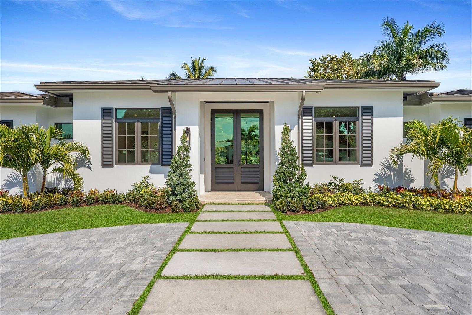 A white house exterior features a paved walkway leading to a dark double front door — 715 Mission Hill Road, Boynton Beach FL 33435, BOYNTON BEACH, FL