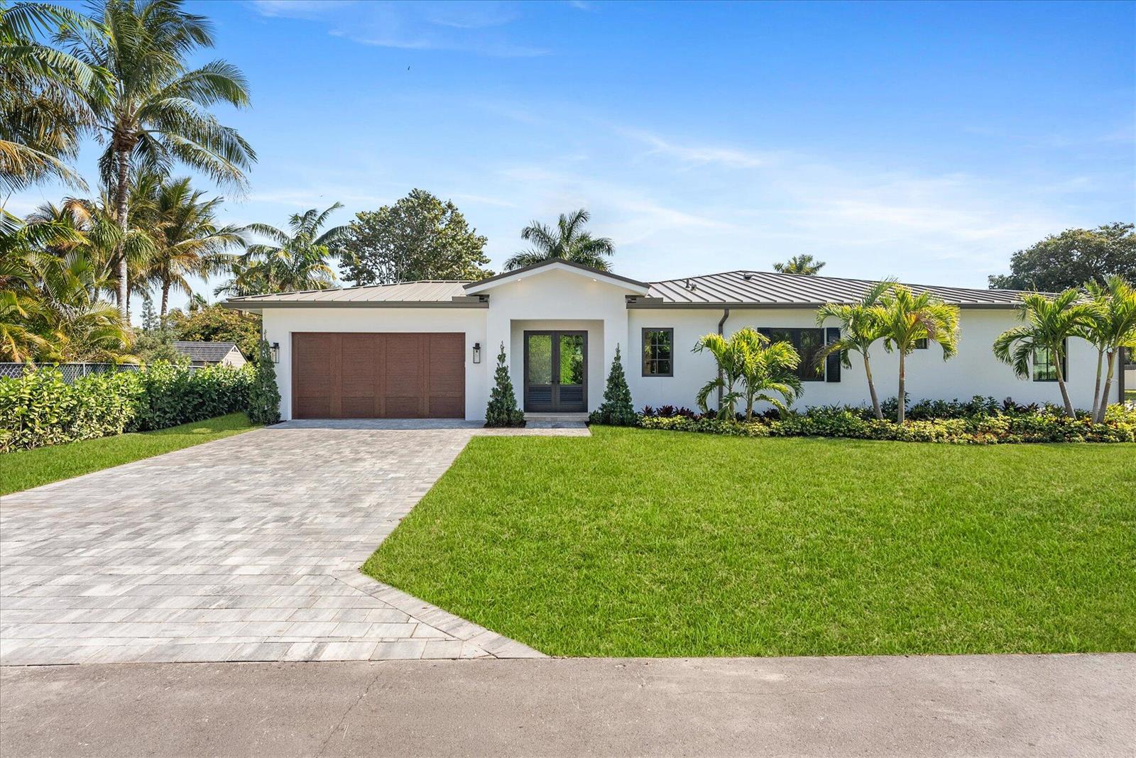 A single-story white house with a metal roof, wooden garage door, and palm trees — 715 Mission Hill Road, Boynton Beach FL 33435, BOYNTON BEACH, FL
