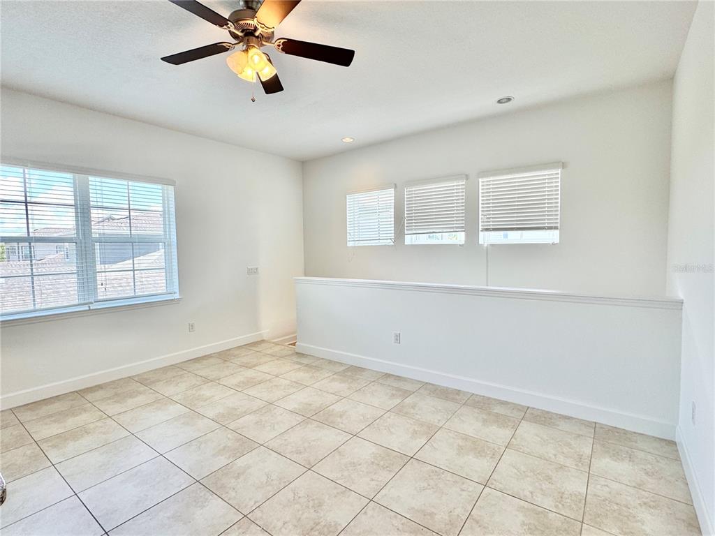 An empty room with tiled floors, a ceiling fan, and windows with white blinds — 14016 DUNANT LANE, ORLANDO, FL