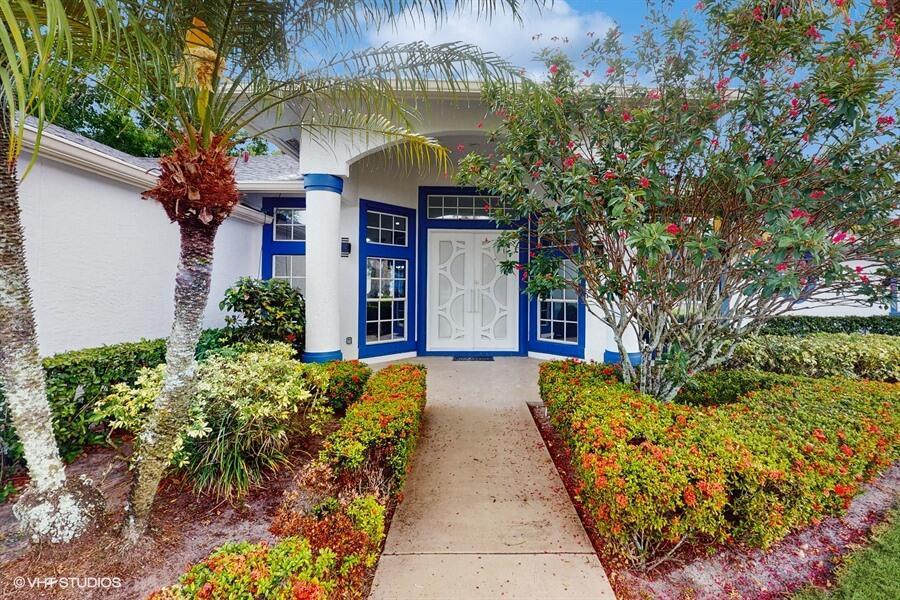 A concrete walkway leads to the white double front doors of a house with blue trim — 13646 Callington Drive, Wellington FL 33414, WELLINGTON, FL
