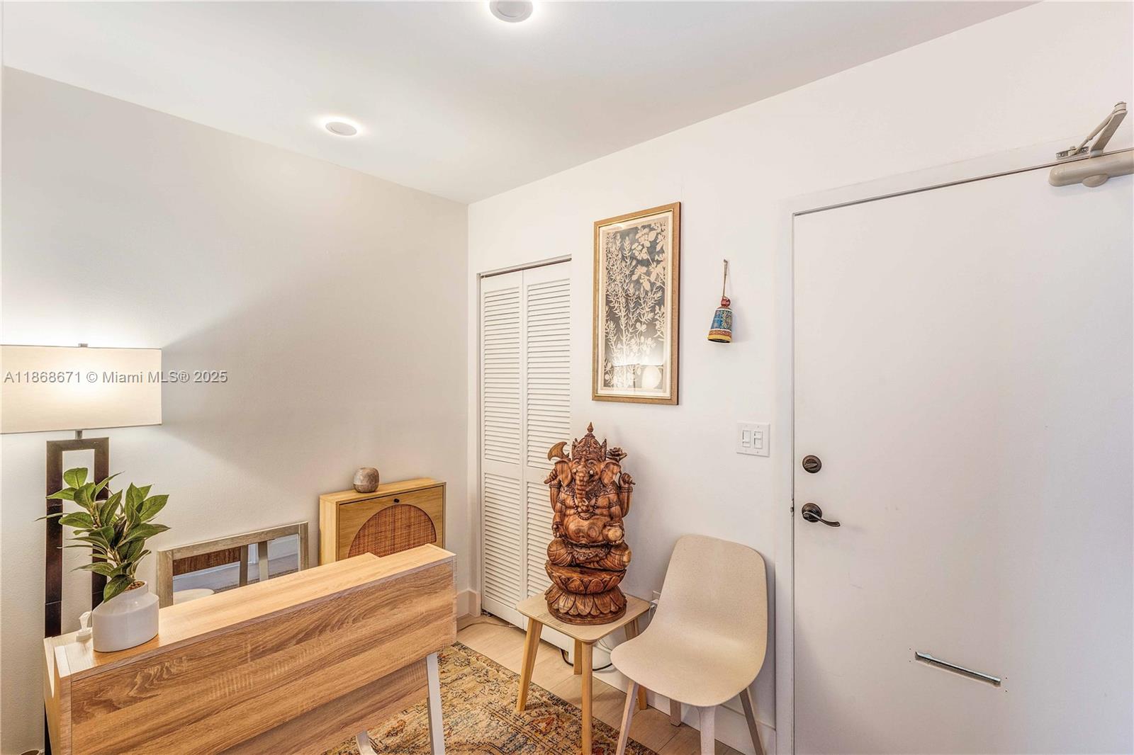 This room features a wooden desk, a Ganesha statue, a chair, and a white door — 1385 SW 22nd St # 201, Miami FL 33145, MIAMI, FL