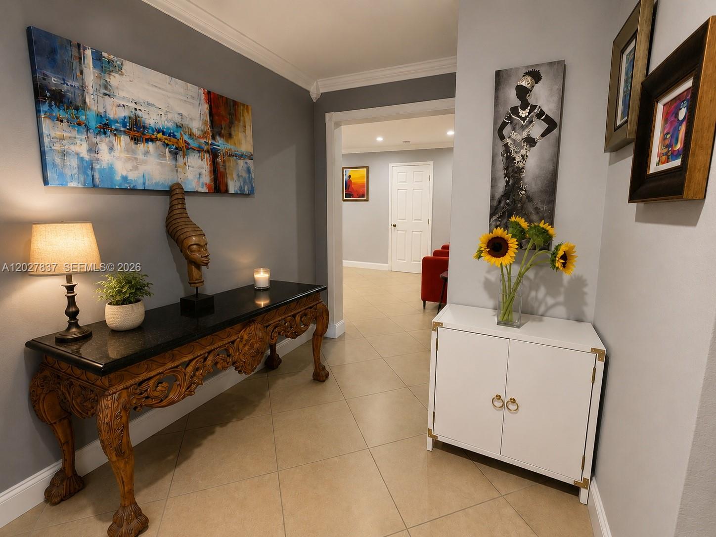 A hallway features a carved wooden console table, a white cabinet, and wall art — 7513 Grant Ct # A, Hollywood FL 33024, HOLLYWOOD, FL