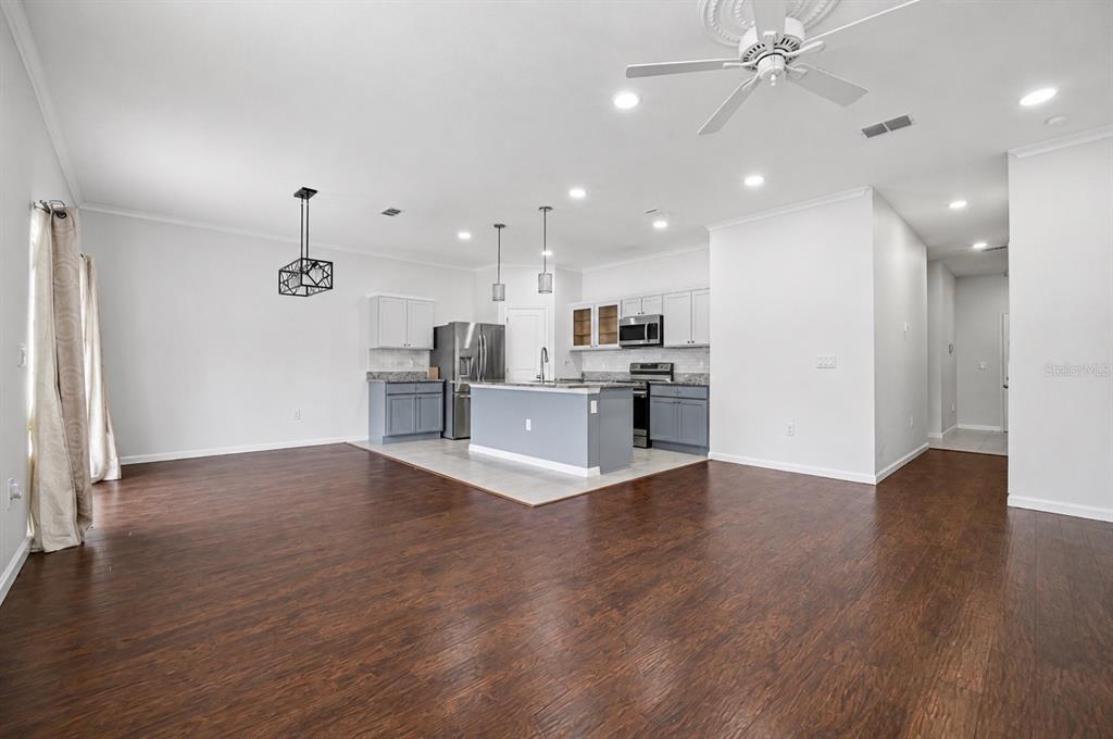 A kitchen with a center island, grey cabinets, and dark wood flooring in an open space — 2270 HEMINGWAY CIRCLE, GROVELAND, FL