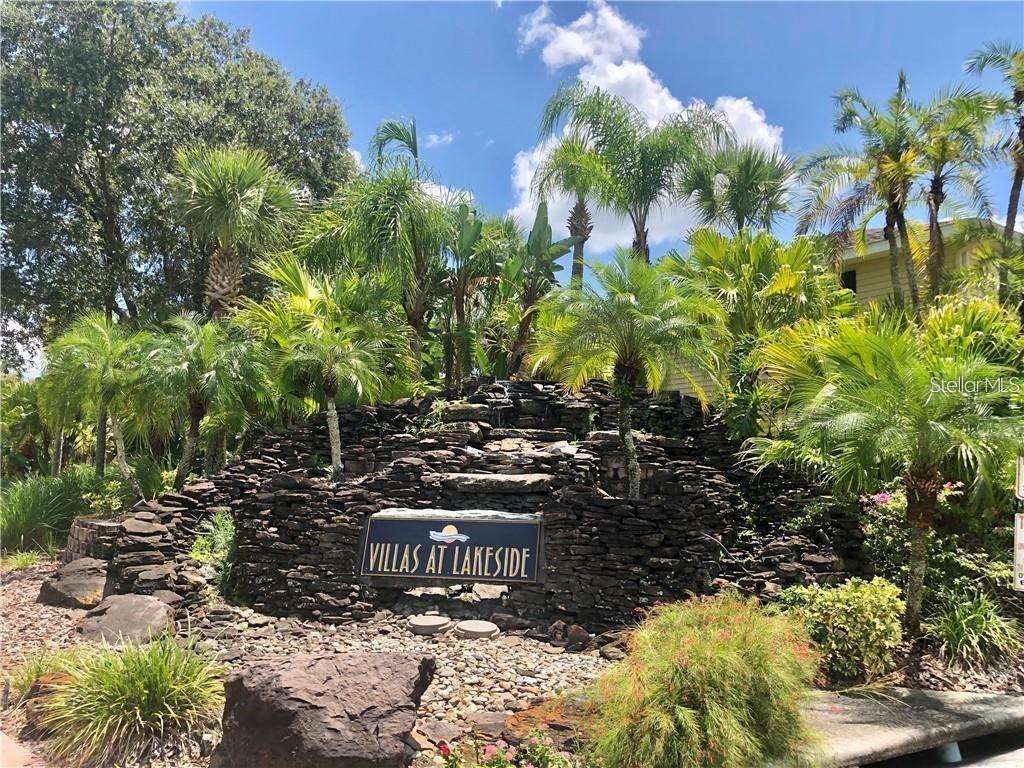 A stone waterfall feature with a sign reading Villas at Lakeside surrounded by palm trees — 1919 SUMMER CLUB DRIVE UNIT 207, OVIEDO, FL