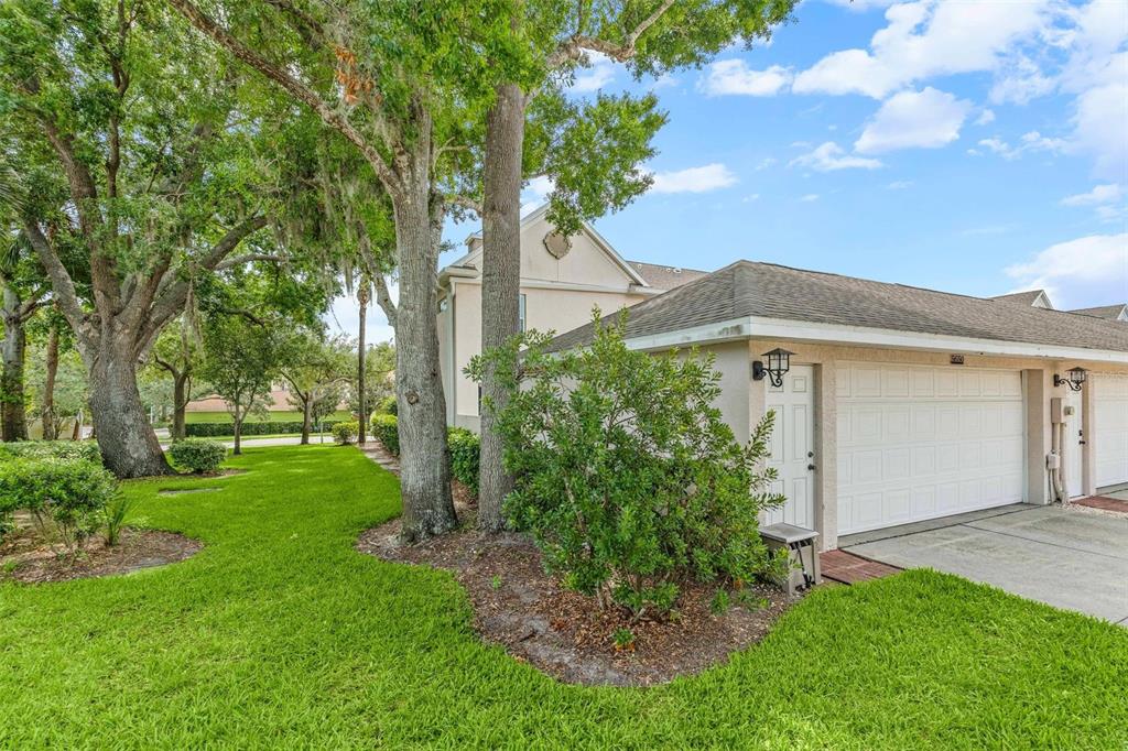A side view of a residential garage with a white door and a grassy yard — 5650 DUVAL STREET, BRADENTON, FL