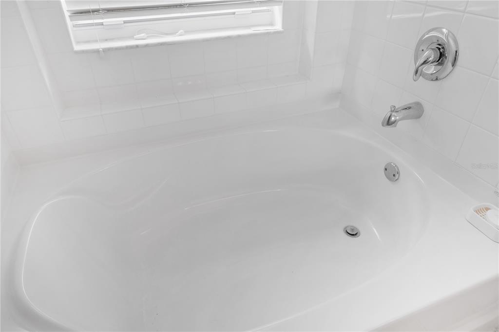 A white soaking tub is installed in a tiled alcove with chrome fixtures — 6923 WATERBROOK COURT, GIBSONTON, FL