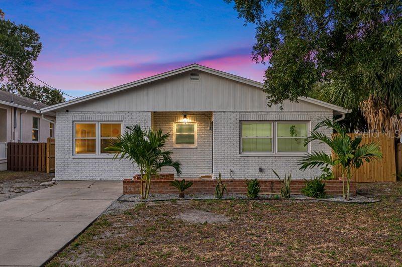 A single-story white brick house with a concrete driveway and a small front yard — 4409 W PEARL AVENUE, TAMPA, FL
