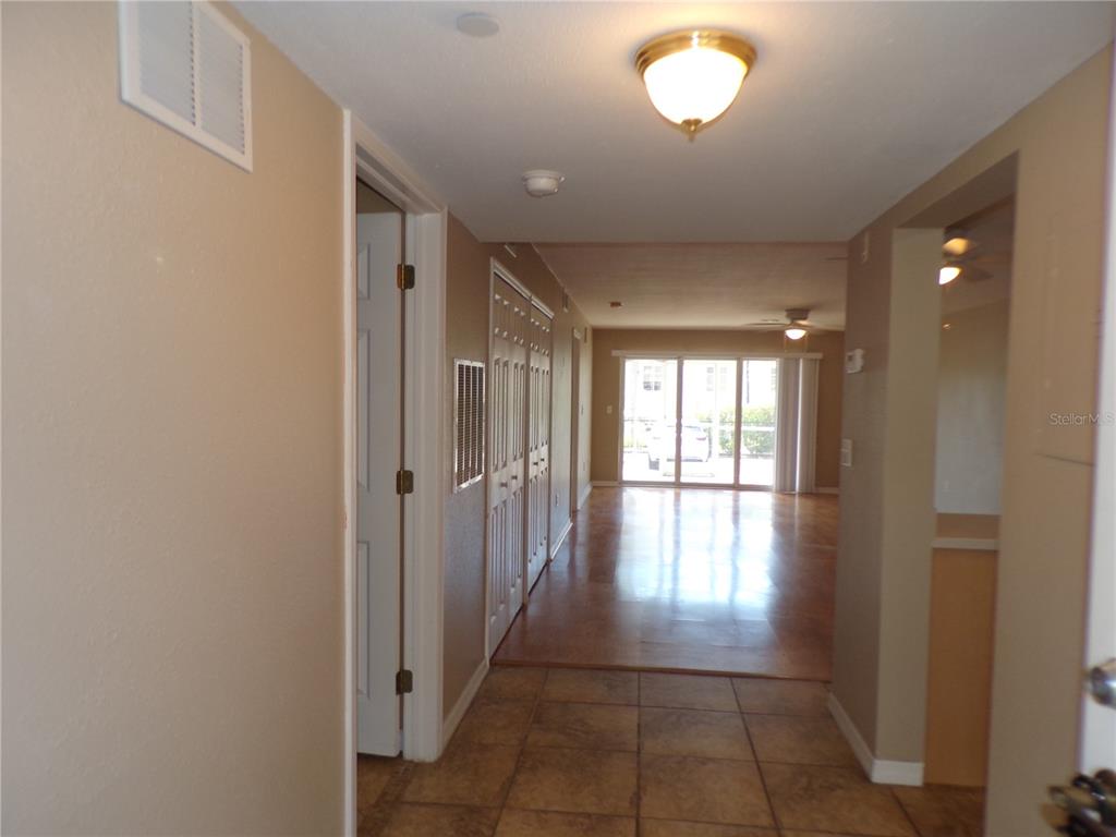 A tiled entryway leads to a living area with wood-look flooring and sliding glass doors — 150 HARBORSIDE AVENUE UNIT 133, PUNTA GORDA, FL