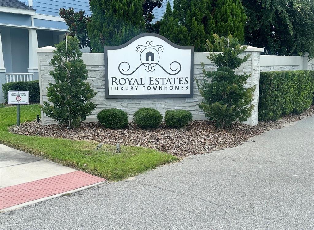 A stone monument sign for Royal Estates Luxury Townhomes stands in a landscaped garden bed — 12113 VIA CASELLI LANE, WINDERMERE, FL