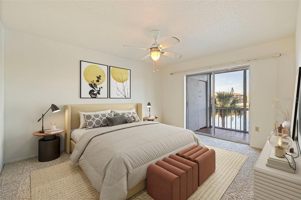A bedroom features a bed, two ottomans, a ceiling fan, and a sliding glass door — 3408 LAKE BAYSHORE DRIVE UNIT P-317, BRADENTON, FL
