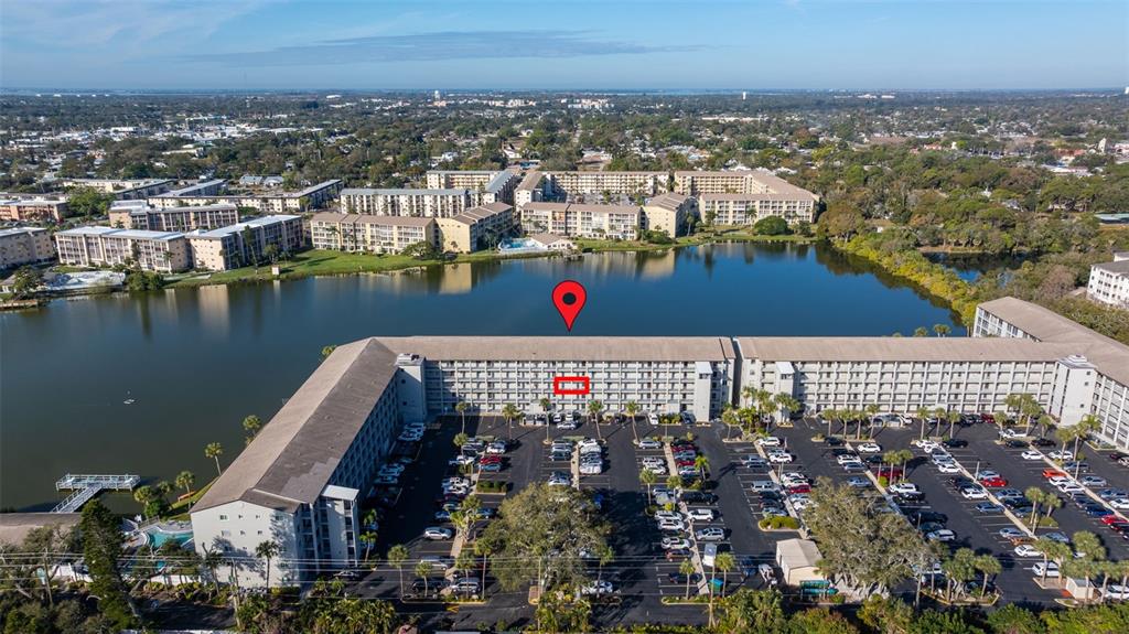 An aerial view shows a large apartment complex situated beside a lake with parking — 3408 LAKE BAYSHORE DRIVE UNIT P-317, BRADENTON, FL