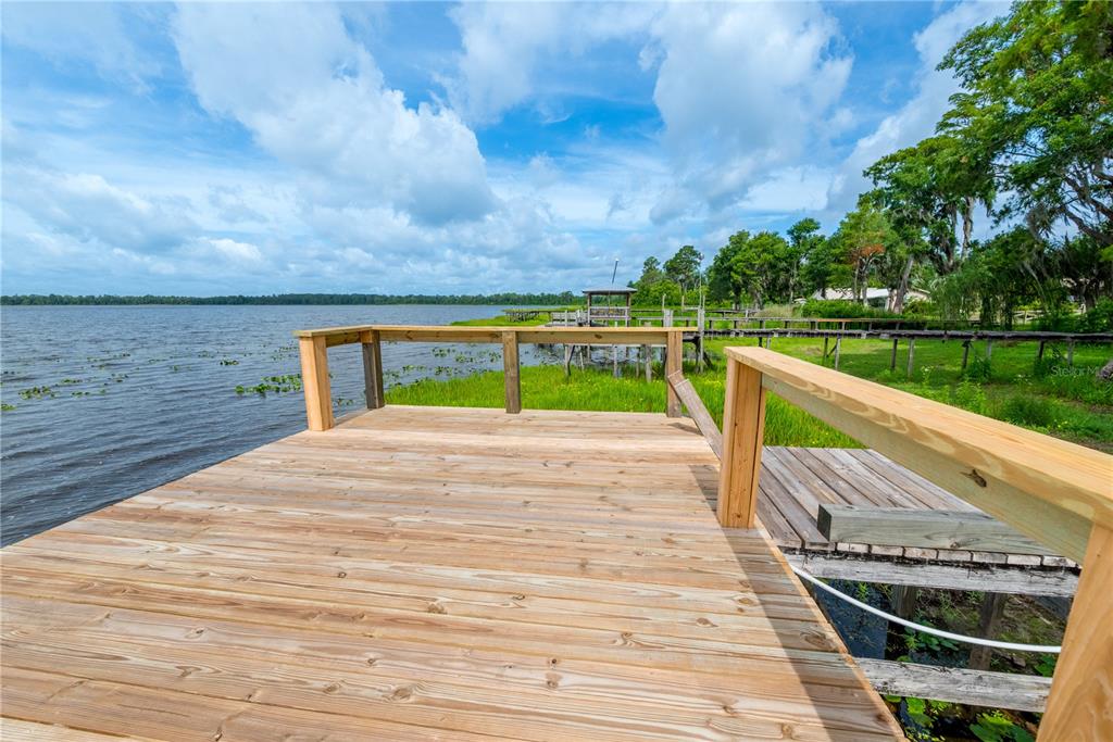 A newly constructed wooden deck overlooks a lake with a small dock nearby — 6600 SW 160TH STREET, STARKE, FL