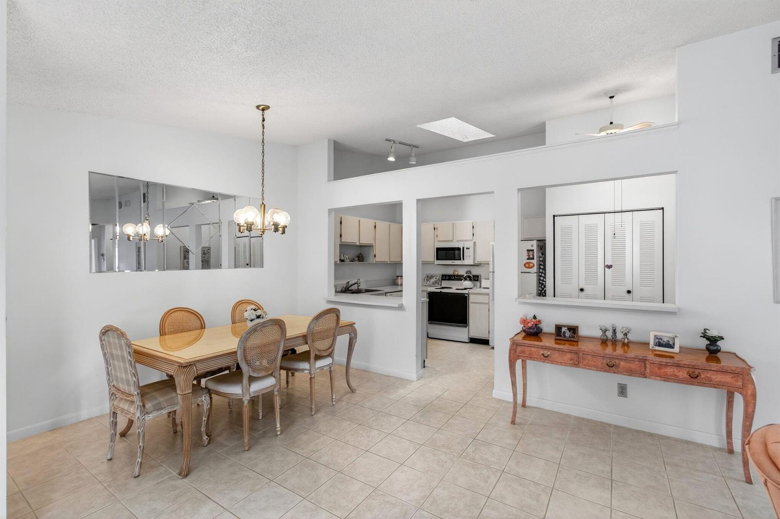 A dining room with a table, chairs, tile floors, and an open pass-through to the kitchen — 3814 Coco Loba Lane, Boynton Beach FL 33436, BOYNTON BEACH, FL