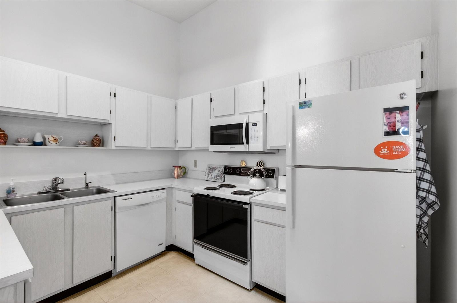 A white kitchen features white cabinets, a dishwasher, an electric stove, and a refrigerator — 3814 Coco Loba Lane, Boynton Beach FL 33436, BOYNTON BEACH, FL