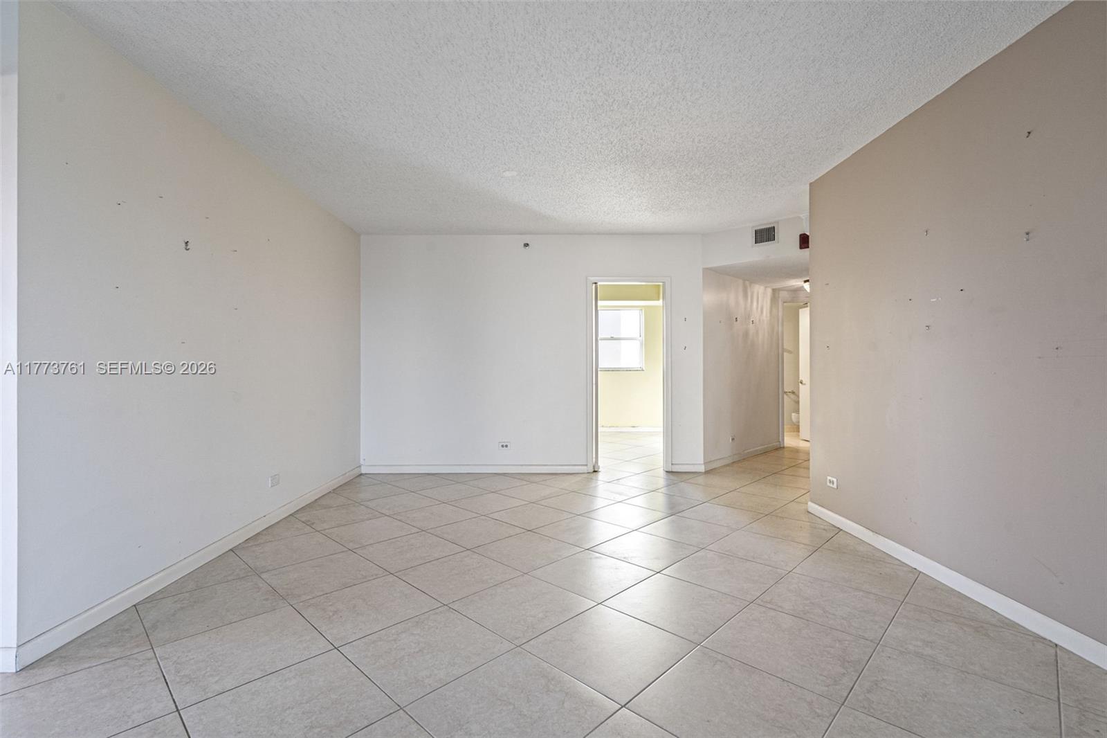 An empty room features beige tile flooring, white walls, and a doorway leading to another space — 7200 Radice Ct # 709, Lauderhill FL 33319, LAUDERHILL, FL