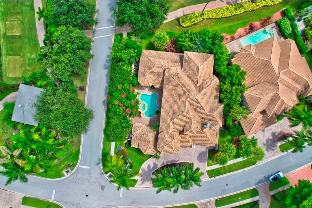 An aerial view shows a house with a tiled roof, a swimming pool, and landscaping — 7635 Mandarin Drive, Boca Raton FL 33433, BOCA RATON, FL