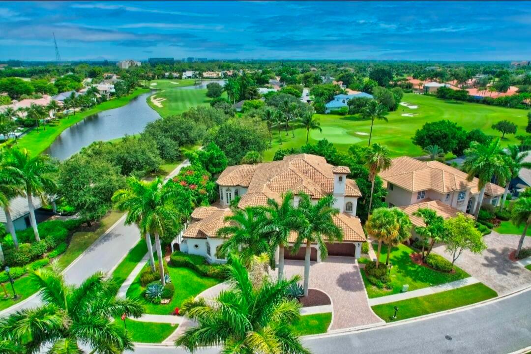 An aerial view of a large house with a tiled roof overlooking a golf course — 7635 Mandarin Drive, Boca Raton FL 33433, BOCA RATON, FL