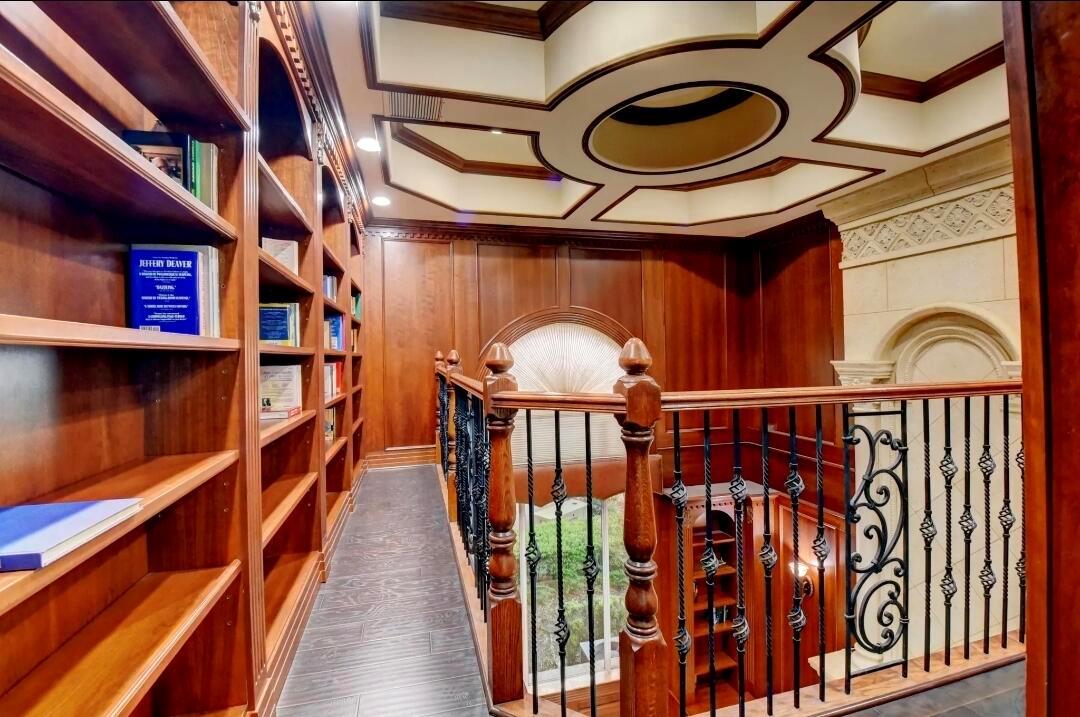 A library loft features wood-paneled walls, built-in bookshelves, a coffered ceiling, and a wrought-iron railing — 7635 Mandarin Drive, Boca Raton FL 33433, BOCA RATON, FL