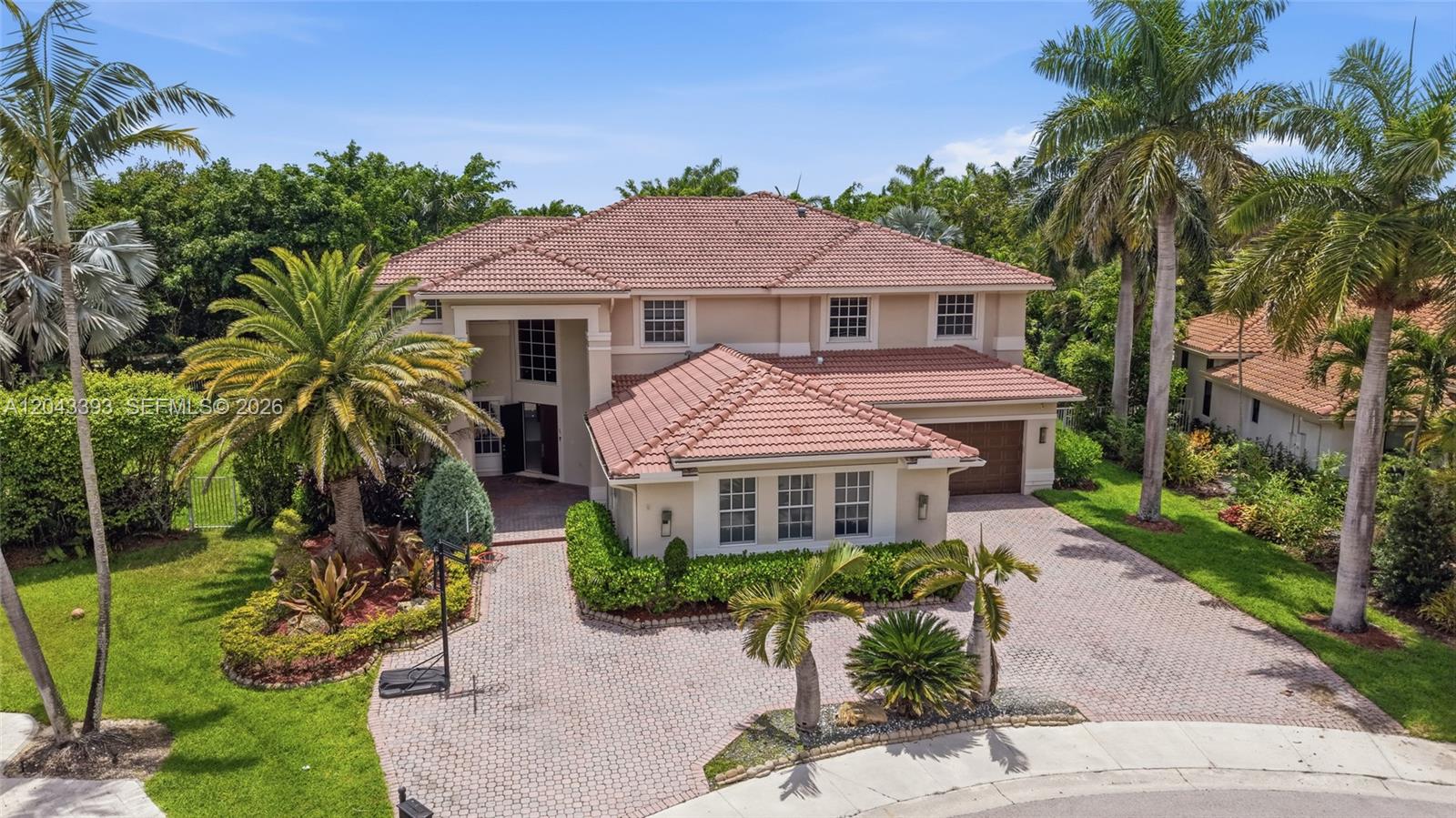 A two-story house with a tiled roof, brick driveway, and palm trees in the yard — 1585 Victoria Isle Way, Weston FL 33327, WESTON, FL