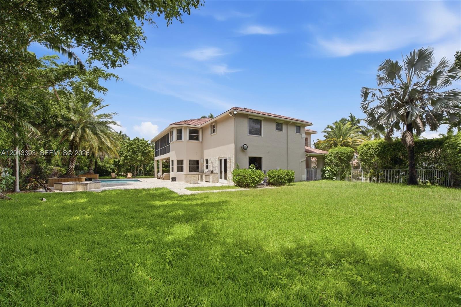 The exterior of a two-story house features a backyard with a pool and palm trees — 1585 Victoria Isle Way, Weston FL 33327, WESTON, FL