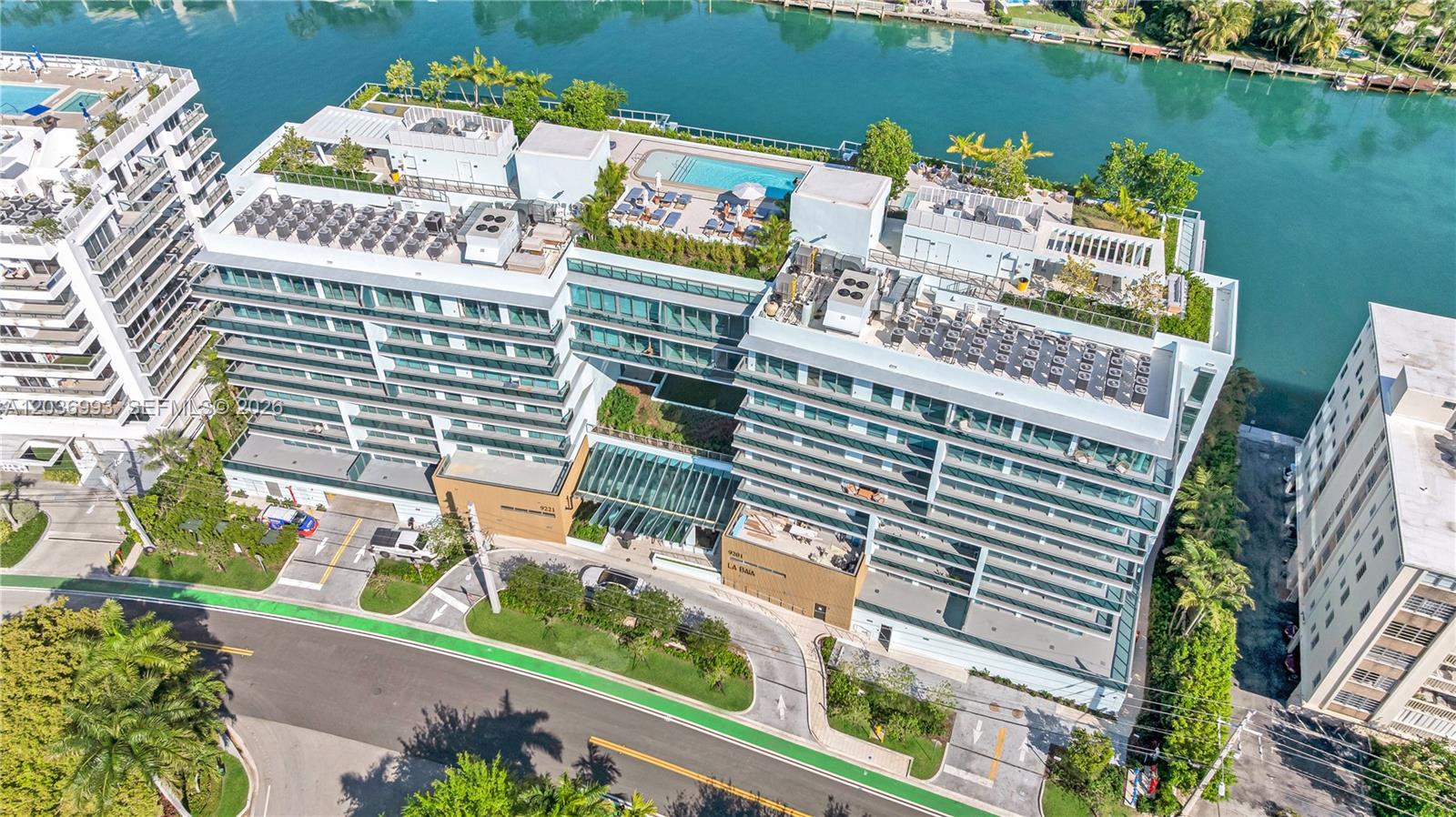 An aerial view of a modern multi-story residential building with a rooftop pool and landscaping — 9221 E Bay Harbor Drive # 512, Bay Harbor Islands FL 33154, BAY HARBOR ISLANDS, FL